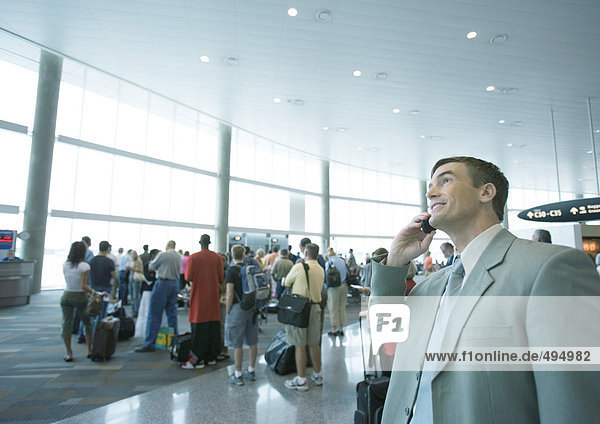 Businessman using phone in airport boarding area