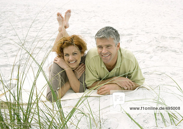 Mature couple lying on beach  front view