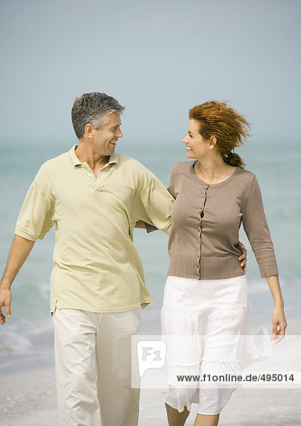 Reife Paare beim Spaziergang am Strand