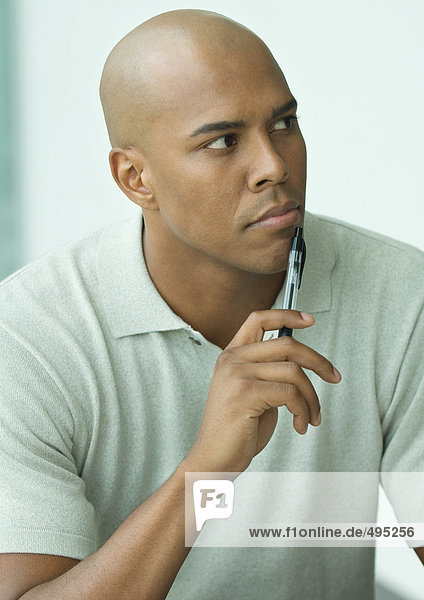 Man holding pen to chin  portrait
