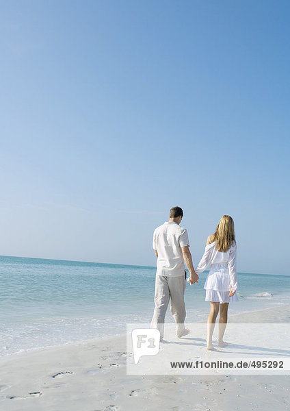 Couple walking on beach  rear view