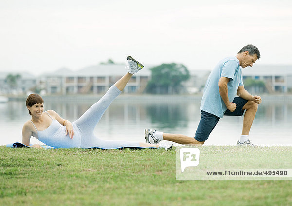 Mature couple exercising  lakeside
