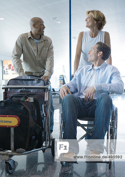 Reisende im Flughafen  einer im Rollstuhl