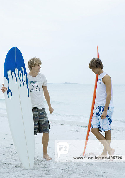 Zwei Surfer stehen am Strand