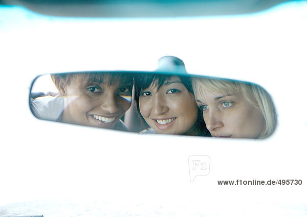 Drei junge Frauen  Gesichter im Rückspiegel reflektiert
