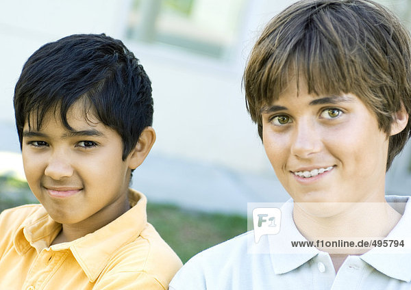 Zwei Jungen  die vor der Kamera lächeln.