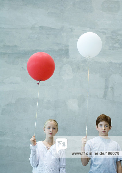 Zwei Kinder halten Luftballons