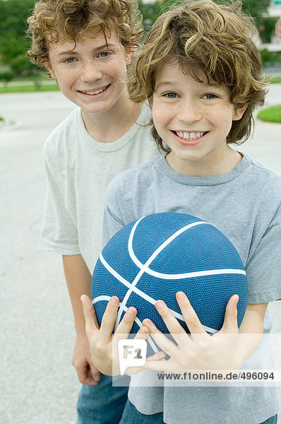 Zwei Jungen  einer hält Basketball  Portrait