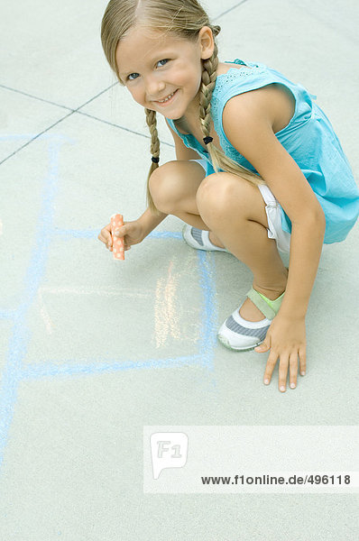 Mädchen Zeichnung hopscotch Spiel auf der Einfahrt