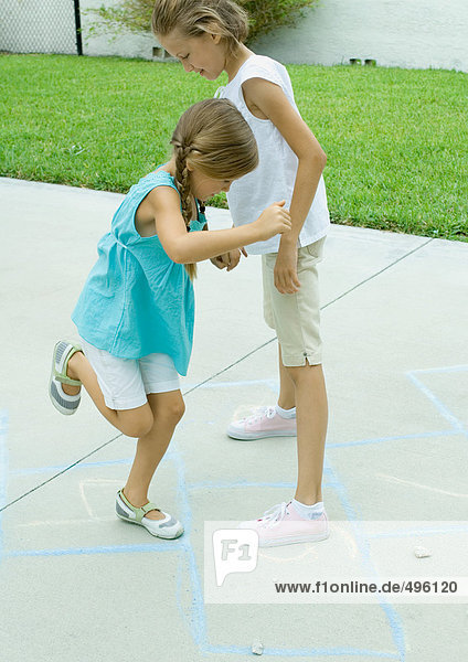Mädchen spielen Hopscotch