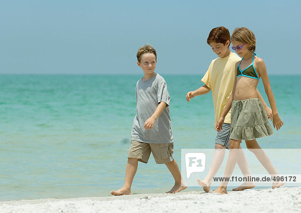 Drei Kinder beim Surfen am Strand