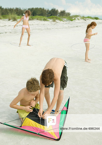 Jungs bereiten Drachen am Strand vor