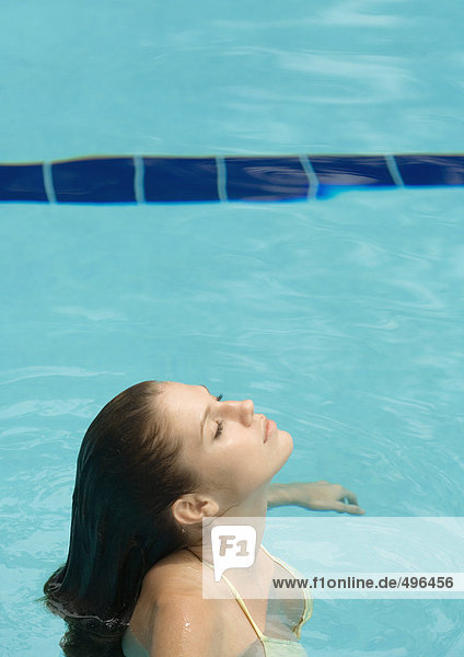 Frau im Pool stehend  Kopf zurück und Augen geschlossen  Seitenansicht