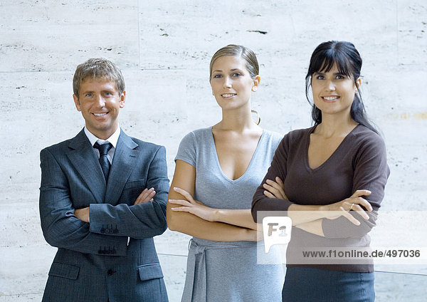 Three business executives standing with arms folded  portrait