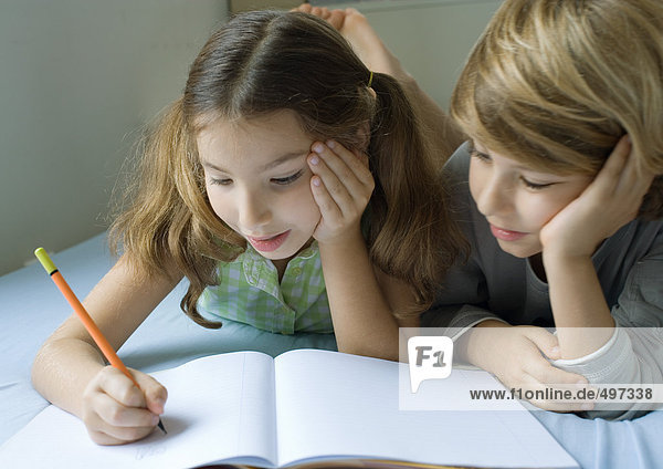 Zwei Kinder machen gemeinsam Hausaufgaben