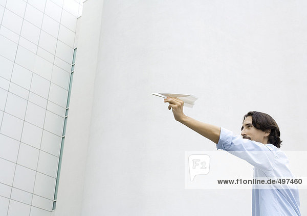 Man holding up paper airplane  low angle view
