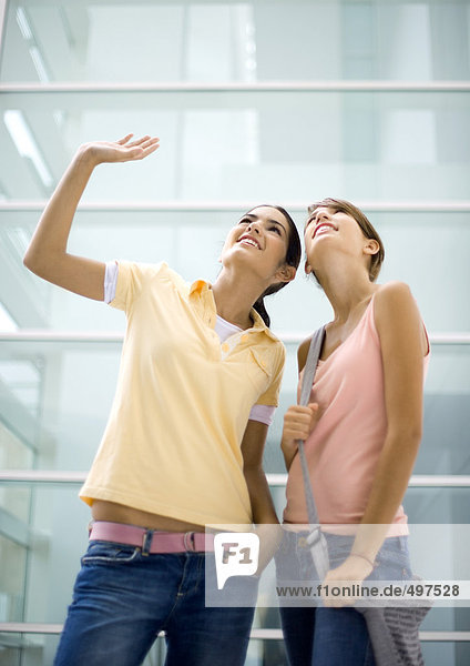 Two teenage girls looking up  one waving
