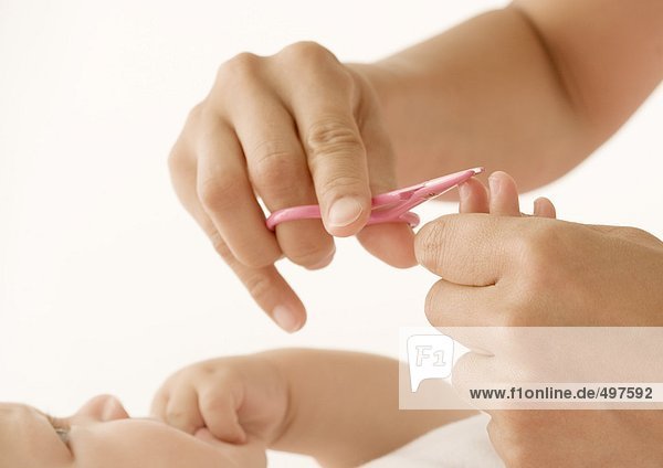 Baby having fingernails cut