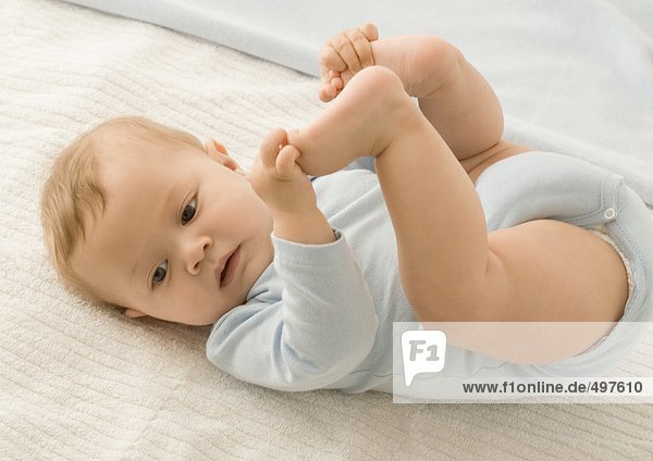 Baby holding feet