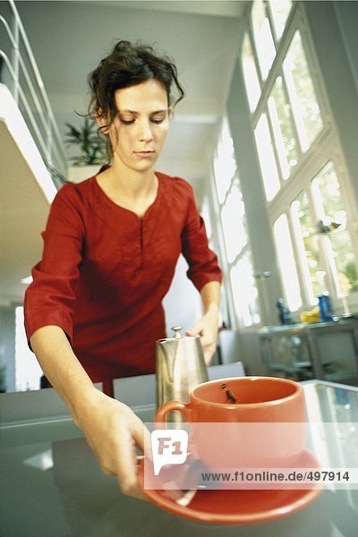 Woman picking up cup and saucer