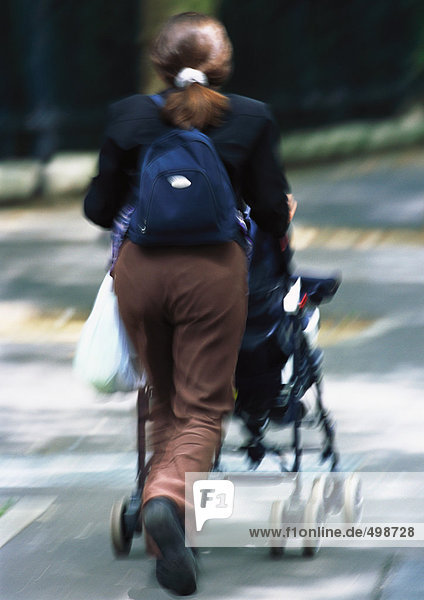 Frau schiebt Kinderwagen