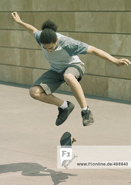 Junger Mann macht Trick auf dem Skateboard