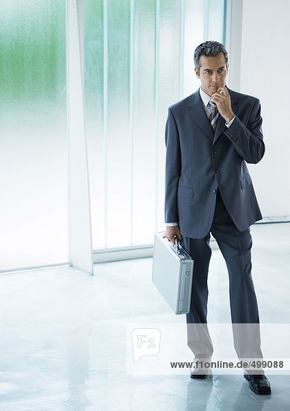 Businessman standing in lobby  holding briefcase