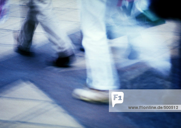 People walking on sidewalk  blurred motion
