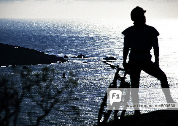 Cyclist looking at the sea  rear view  silhouette