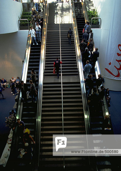 Menschen auf Rolltreppen und Treppen
