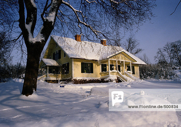 Schweden,  schneebedecktes Haus in ländlicher Umgebung bei Tageslicht,  schneebedeckter Boden