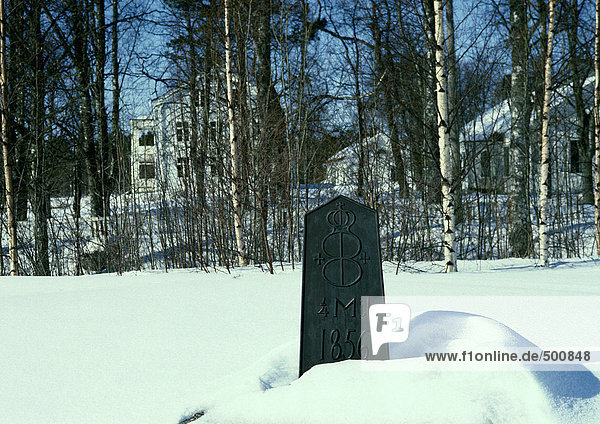 Sweden  marker in snow  houses in woods in background