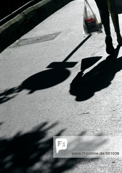 Person auf der Straße mit Tasche,  Schatten.