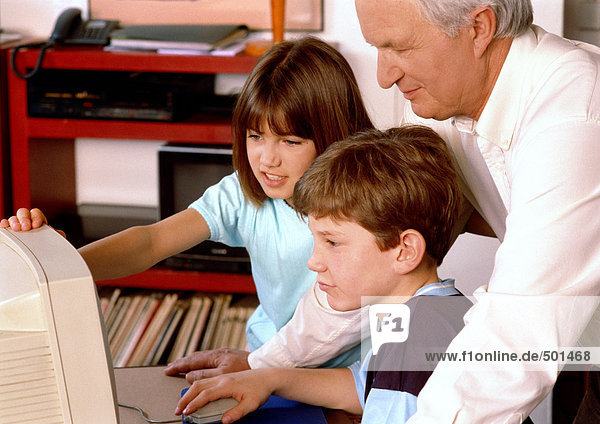 Kinder  die mit ihrem Vater am Computer arbeiten.