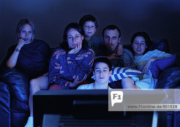 Familie beim gemeinsamen Fernsehen im Dunkeln.