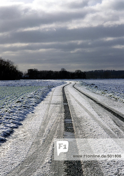 Frankreich  Picardie  Straße durch Felder mit Schnee