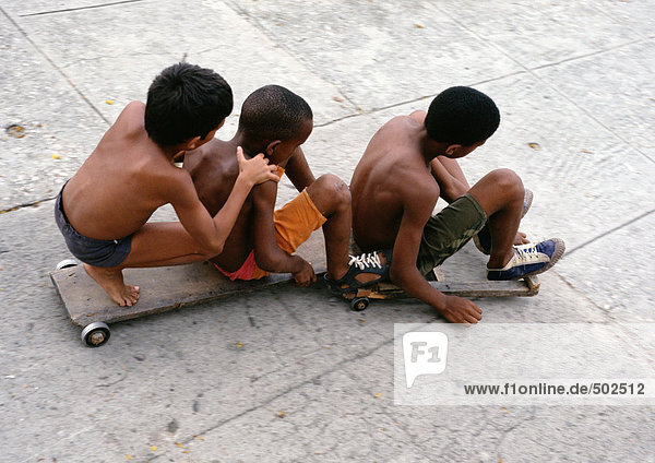 Drei Jungen auf Skateboards sitzend  erhöhte Aussicht