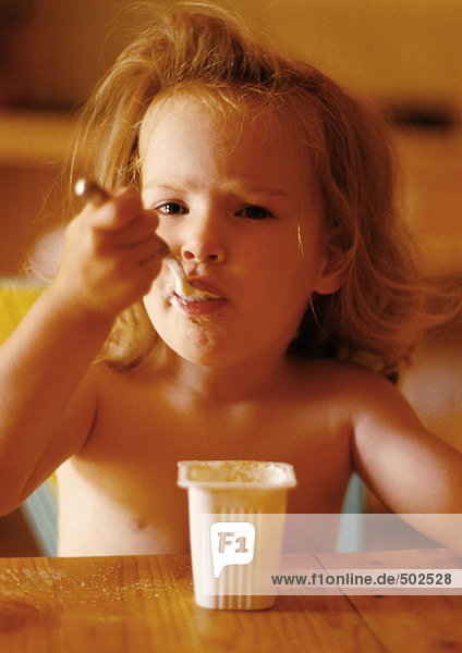 Kleines Mädchen isst Joghurt  Portrait