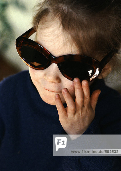 Kleines Mädchen mit übergroßer Sonnenbrille
