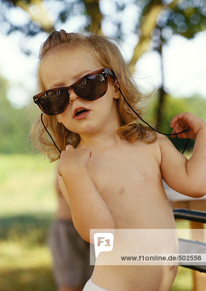 Little girl wearing oversized sunglasses