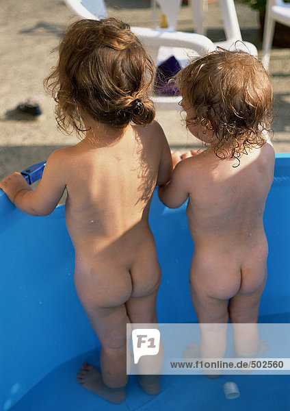 Zwei Kinder im Wasser stehend  Rückansicht