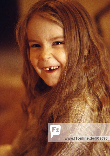 Kleines Mädchen lächelt mit fehlendem Zahn