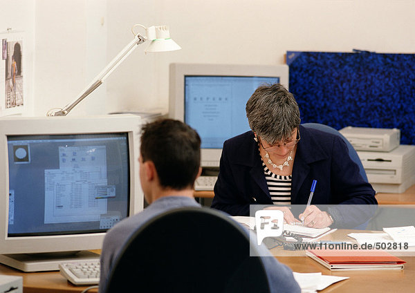 Man and woman sitting in office