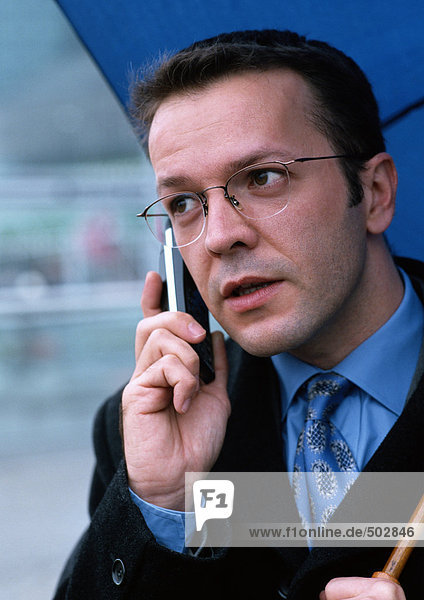 Mann mit Handy und Regenschirm Portrait