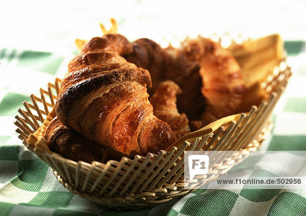 Croissants im Korb auf grün karierter Tischdecke,  Nahaufnahme