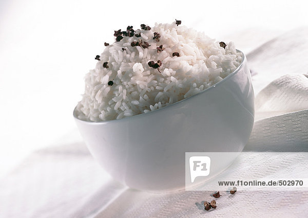Weiße Schale mit weißem Reis,  bestreut mit einem Gewürz,  Nahaufnahme