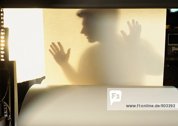 Silhouette des Menschen hinter einem Blatt Papier