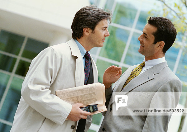 Two businessmen standing face to face  side view