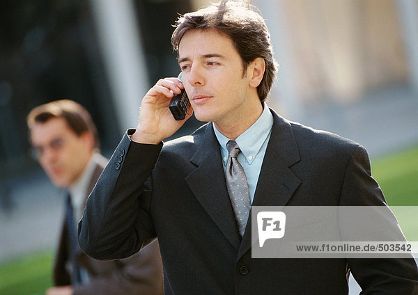 Businessman using cell phone  outside