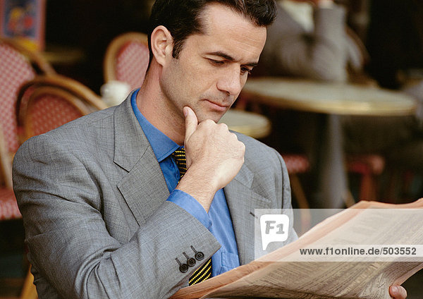 Businessman reading  hand under chin  portrait